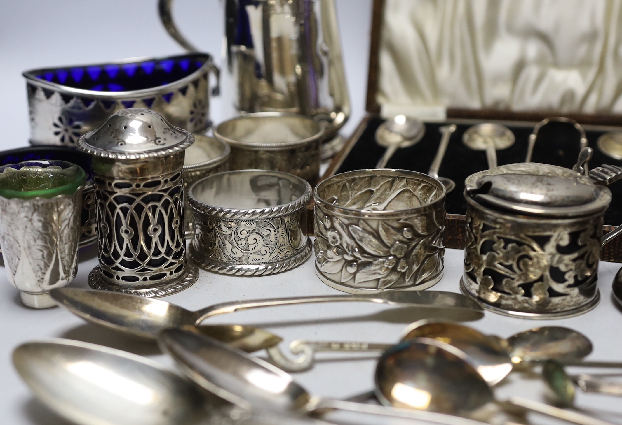 A collection of small silver to include a christening cup, a pair of late Victorian navette shaped salts, a Chinese white metal cruet (incomplete), flatware including cased teaspoons, vest case, napkin rings, etc.